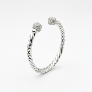 Silver bracelet with two textured ball charms on a white background