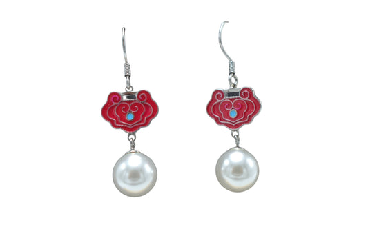 Pair of earrings with red floral designs and pearl drops on a white background